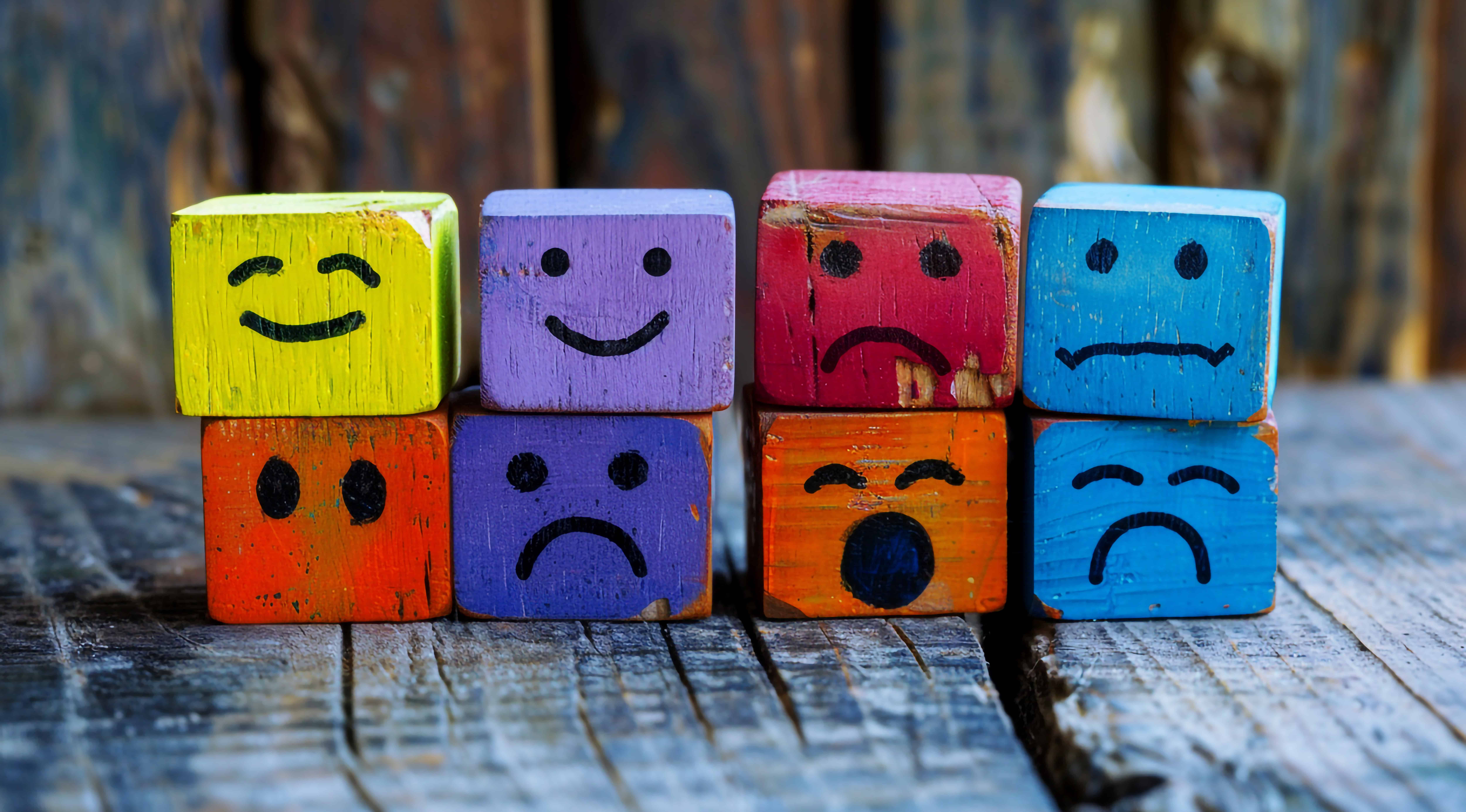colorful-wooden-cubes-with-different-happy-sad-faces-them-sitting-each-other